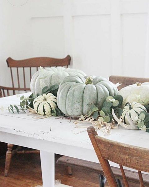 a farmhouse fall centerpiece of heirloom pumpkins and gourds, antlers and greenery for decorating for the fall