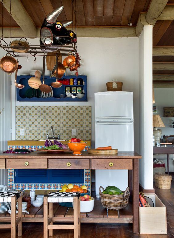 a large stained open storage kitchen island with drawers and a hanging metal holder over it for maximal storage