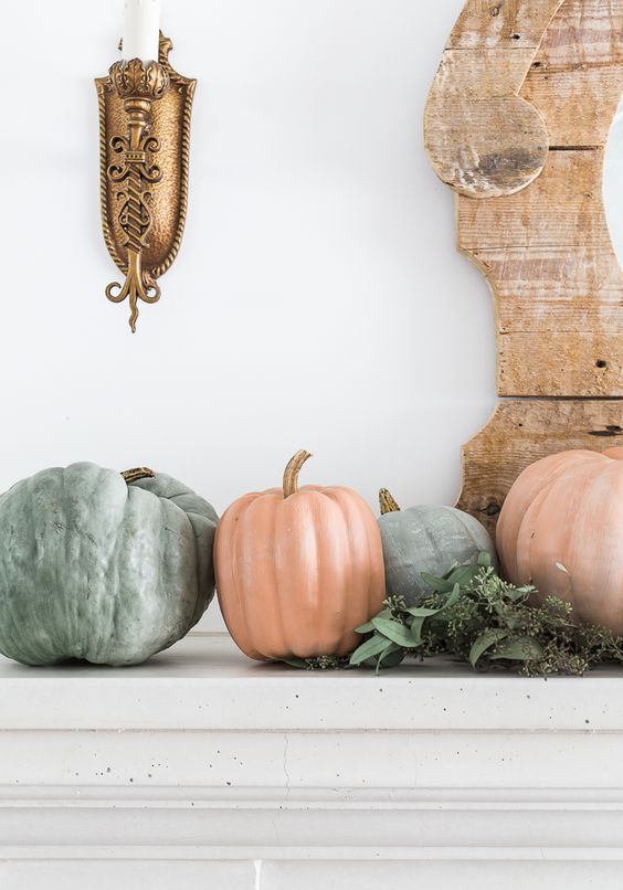 a natural fall mantel with lots of pumpkins and eucalyptus is a pretty decoration for the fall