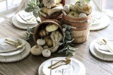 a neutral fall centerpiece of wooden baskets filled with gourds and pumpkins and neutral foliage is ethereal and cool