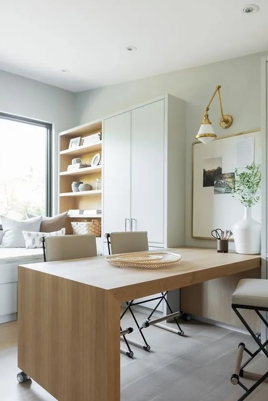 a neutral organic home office in dove grey, with a large wooden desk, a cupboard and a storage unit and a window daybed