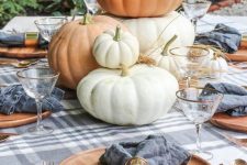 a simple pumpkin stack is always a good idea for a rustic fall centerpiece and can match almost any table setting
