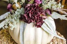 a white pumpkin vase with purple blooms, greenery and more textural elements is a chic fall centerpiece