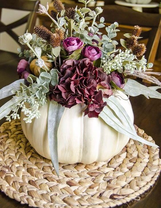 a white pumpkin vase with purple blooms, greenery and more textural elements is a chic fall centerpiece