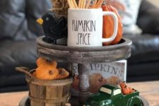 a wooden stand with wheat, fake pumpkins, a pretty mug and some colorful figurines