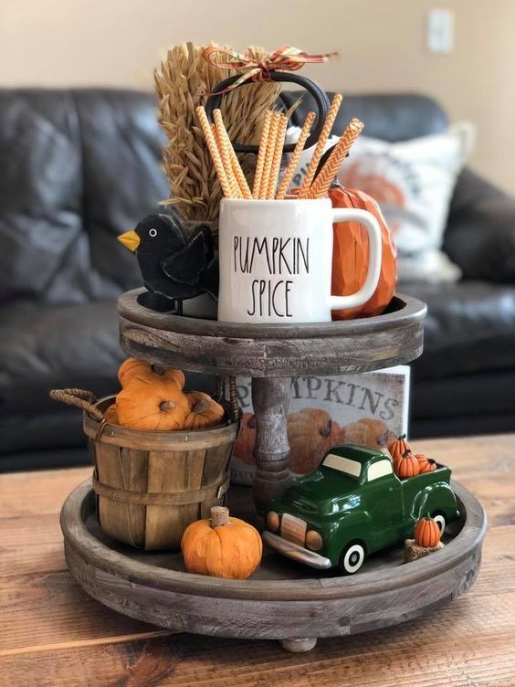 un support en bois avec du blé, de fausses citrouilles, une jolie tasse et des figurines colorées un support en bois avec du blé, de fausses citrouilles, une jolie tasse et des figurines colorées