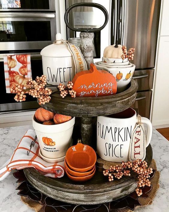 a wooden stand with white and orange porcelain, berries, fake pumpkins and plaid napkins for the fall