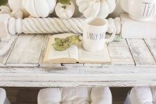 an airy fall centerpiece of white and neutral pumpkins, fall leaves and railing for a neutral vintage look