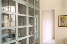 an oversized glass fronted cabinet with many compartments is great for storing your tableware and other stuff