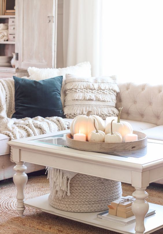 cozy neutral fall decor - a tray with white pumpkins and pillar candles, a white blanket in a basket