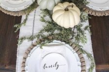neutral pumpkins and greenery, wooden chargers and neutral tableware for a chic fall dinner