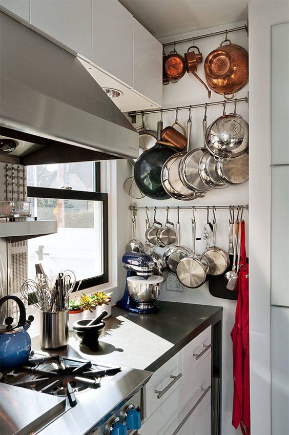 railings built into an awkward nook are great for hanging all the pans, teapots and pots without taking shelf space