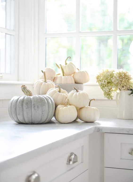 simply stack white pumpkins on the table to create relaxed and chic fall decor with a natural feel