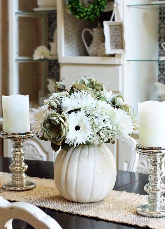 vintage fall centerpiece of white candles and a white pumpkin with white blooms of various kinds