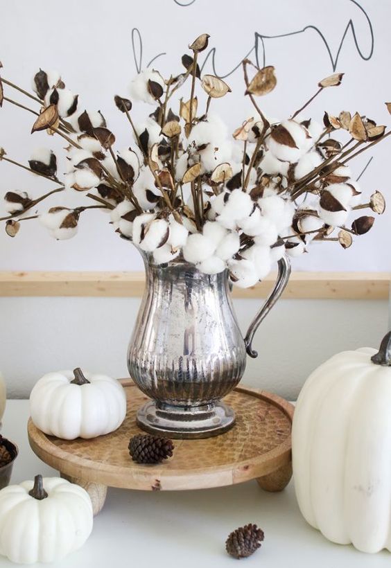 citrouilles blanches, pommes de pin et un arrangement de coton dans une cruche en argent pour une déco automnale élégante et chic citrouilles blanches, pommes de pin et un arrangement de coton dans une cruche en argent pour une déco automnale élégante et chic
