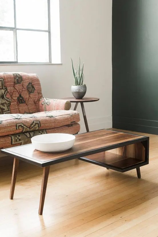 a beautiful mid-century modern coffee table with a curved tabletop that makes an open storage compartment and with black edges