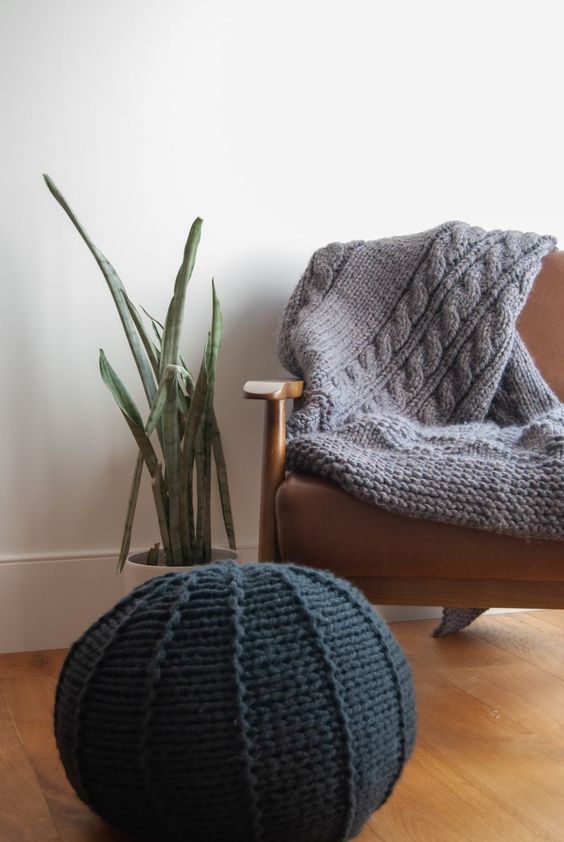 a black knit pouf and a grey knit blanket are a great solution to cozy up your space and make it fall-ready