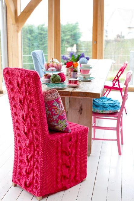 a chair covered with hot pink knit looks super bright and cozy and will make your space very welcoming