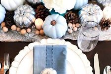 a chic fall tablescape with light blue pumpkins, blue napkins, silver touches, pinecones and wooden beads