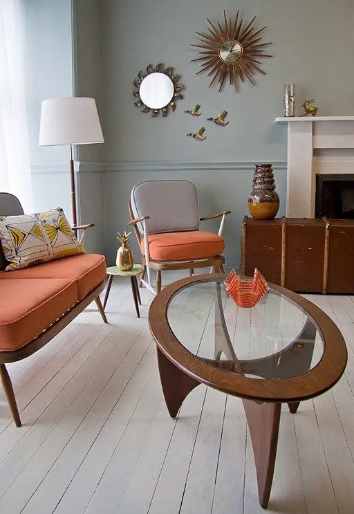 a chic mid-century modern coffee table with an oval glass tabletop and a creatively shaped base made of four legs