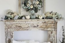 a chic neutral and pastel fall mantel with a faux pumpkin and greenery wreath and the same on the mantel