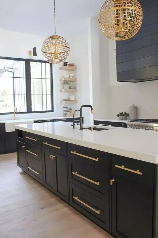 a contrasting graphite grey and white kitchen with gold handles and matching gold globe pendant lamps looks chic