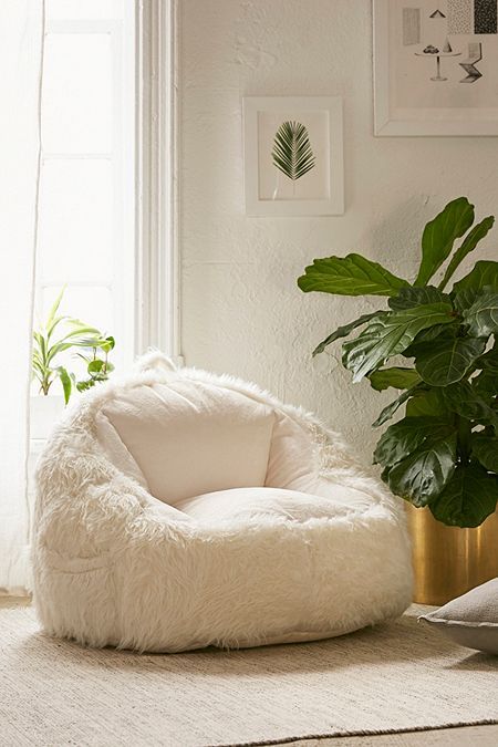 a cozy and comfy white faux sheepskin chair invites you to sit on it and enjoy relaxation and warmth