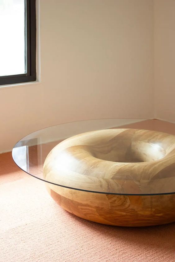 a creative coffee table with a wooden donut as a base and a round glass tabletop is a cool and fun solution for your living room