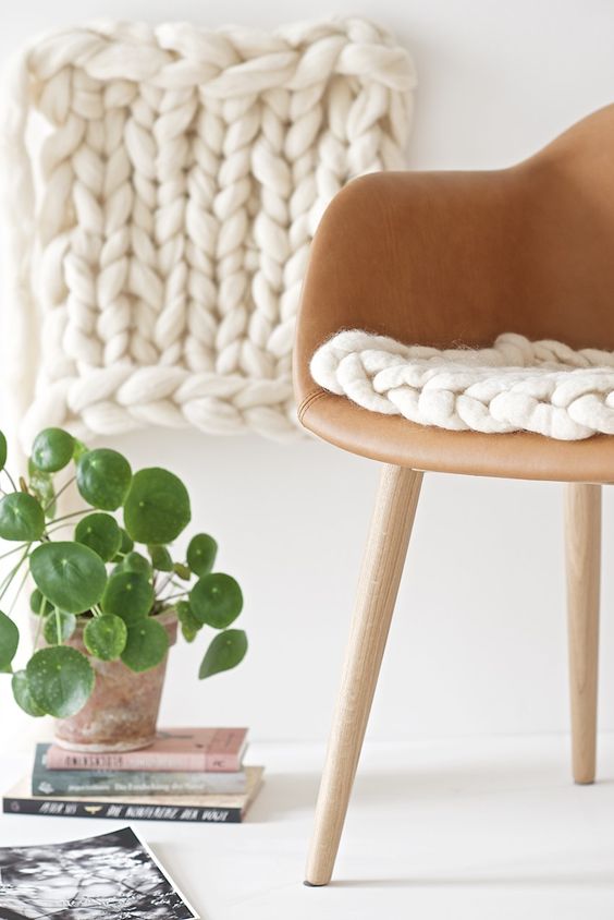 a leather chair with a white chunky knit cushion is much cozier and warmer than a usual one