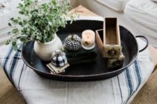 a metal tray with a candle, potted greenery, plaid pumpkins and wooden drawers for a famrhouse feel
