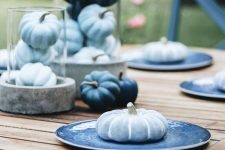 a modern blue fall table setting with light blue and navy pumpkins and plates is lovely