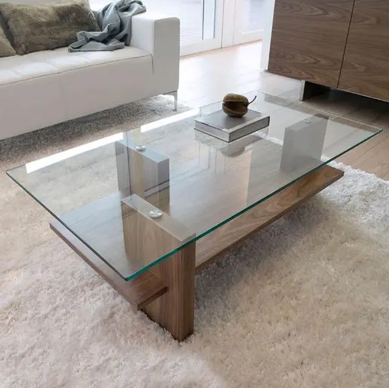 a modern zen coffee table with a wooden base and a glass tabletop, vertical stilts add eye-catchiness