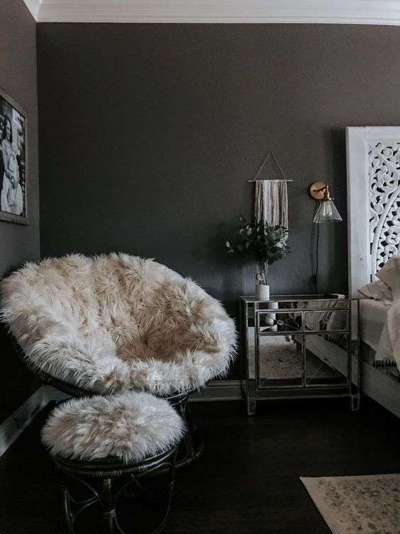 a papasan chair finished off with a white faux fur cover and a matching stool with such a cover for cold months