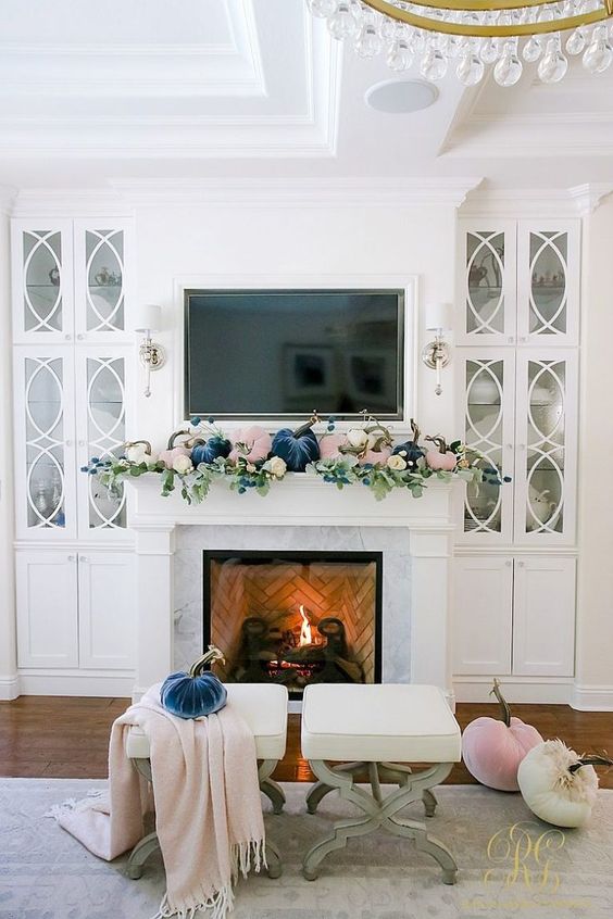 a pastel fall mantel with blush and navy velvet pumpkins and fresh greenery is a cool modern idea