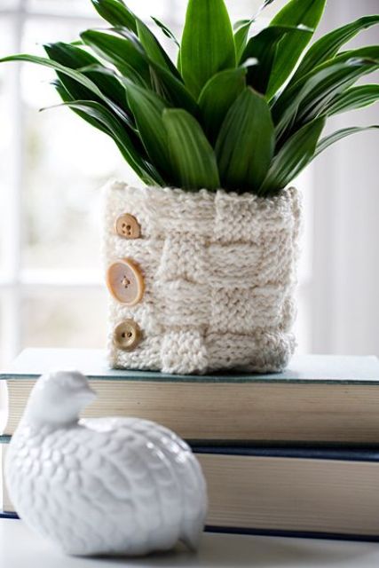 a planter covered with a neutral cozy with buttons is a great idea to spruce it up for the fall or winter