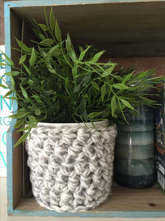 a planter styled with a chunky knit cozy looks very cool, lovely and chic and feels fall or winter-ready