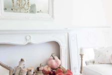 a refined and chic vintage mantel with a mirror in a gorgeous fram and a copper bucket with birch branches plus pink and coral velvet pumpkins