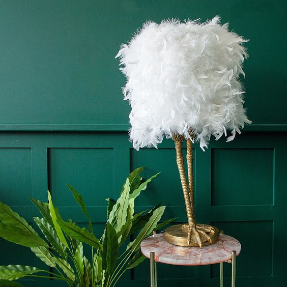 a refined and quirky table lamp of white ostrich feathers and gold leg shaped base is a very fun idea
