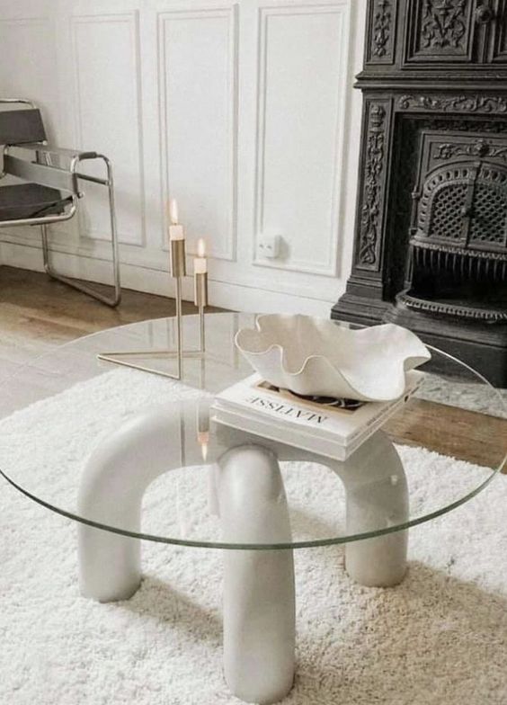 a stylish modern coffee table of arched legs and a round glass tabletop is a cool addition to your living room
