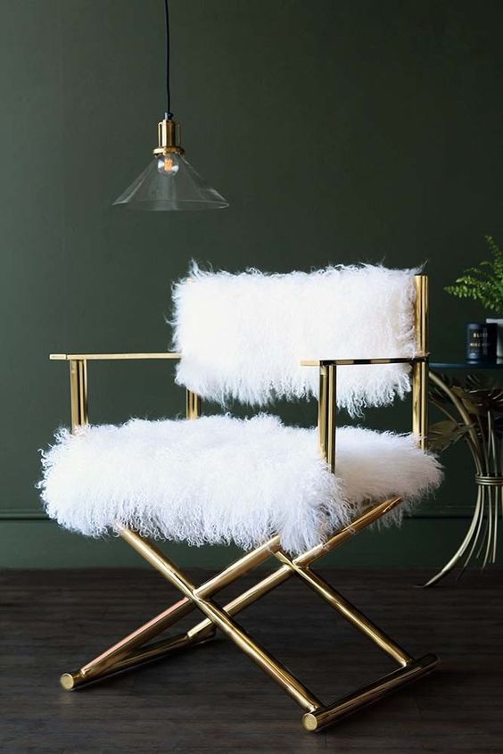 a stylish shiny gold chair with white faux fur is a cool glam piece to complete your space and make it refined