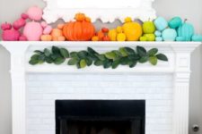 a super colorful fall mantel with super bright pumpkins and birch-inspried candles in the fireplace