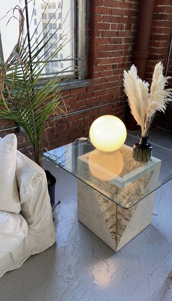 a unique coffee table of a concrete piece with a leaf on top, a glass tabletop is a catchy and chic idea for your living room