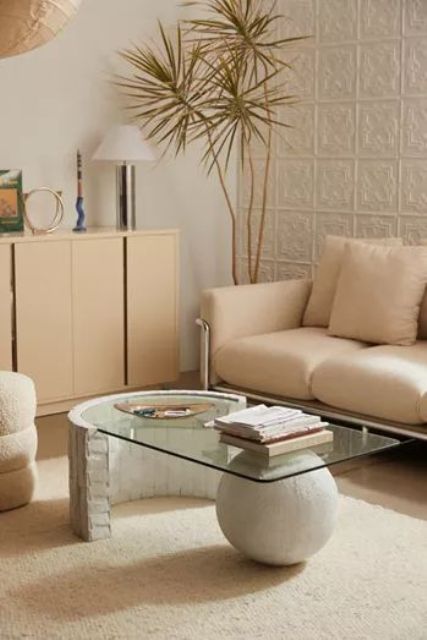 a unique coffee table of concrete and a concrete ball as base and a curved glass tabletop is a stylish idea for a modern space