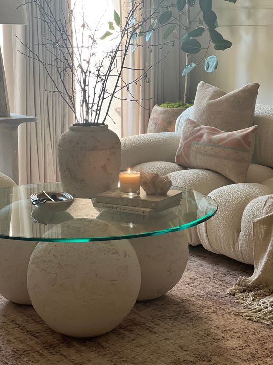 a unique coffee table of plaster balls as a base and round glass tabletop is a dramatic solution for any living room