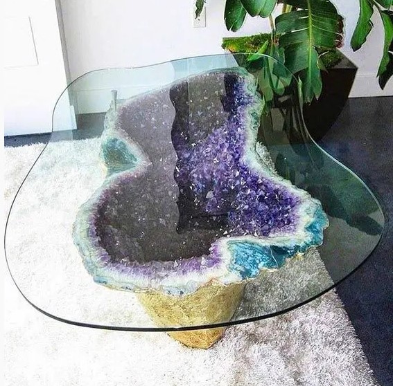 a unique coffee table with an amethyst base gilded on the outside and a matching in shape glass tabletop will be a showstopper