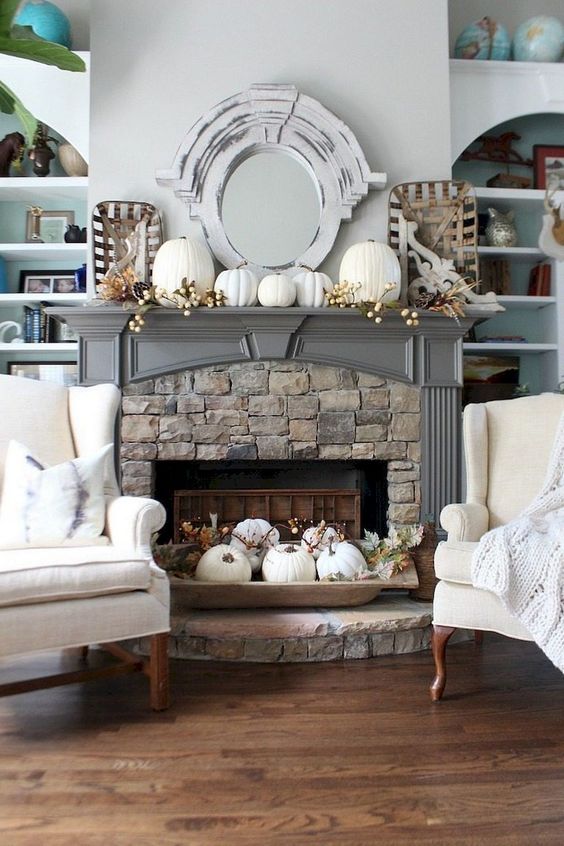 a vintage rustic mantel with fake berries, white pumpkins, a dough bowl with white pumpkins, leaves and berries