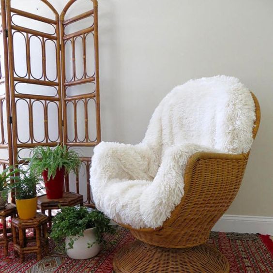 a vintage wicker chair with white faux fur is a stylish piece for a boho chic space or a rustic one