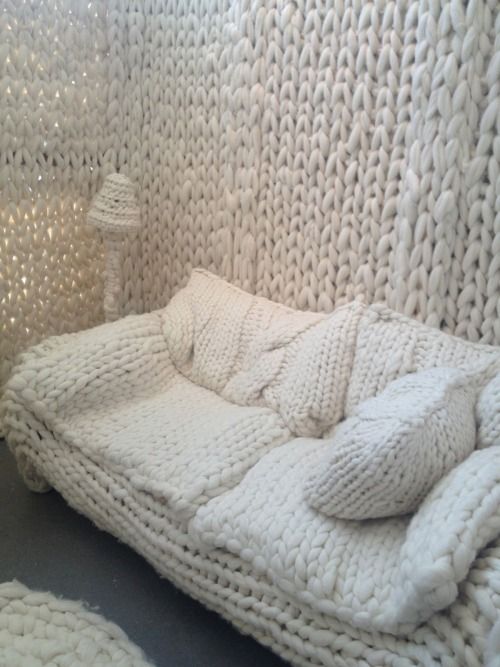 a white chunky knit sofa with matching pillows invites to relax and sleep on it