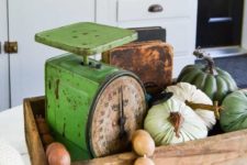 a wooden box with wooden beads, natural and fabric pumpkins and vintage scales for a rustic space