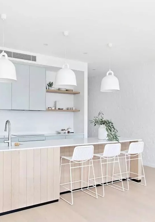  مصابيح معلقة انيقة وعصرية An-airy-coastal-kitchen-with-light-blue-cabinetry-a-large-wooden-kitchen-island-white-mug-shaped-pendant-lamps-white-wicker-stools